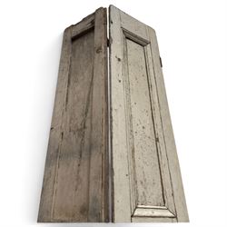 Set of three French 19th century painted pine folding window shutters of tall form, each comprising two hinged leaves with three graduated raised and fielded panels, in antique cream-painted finish