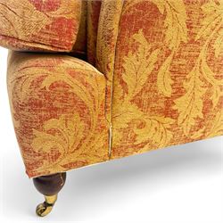 Duresta - Contemporary pair of upholstered armchairs, in red and gold damask style fabric, each with sprung seat and removable cushion back, rolled arms, on turned front supports with brass castors, square back legs 