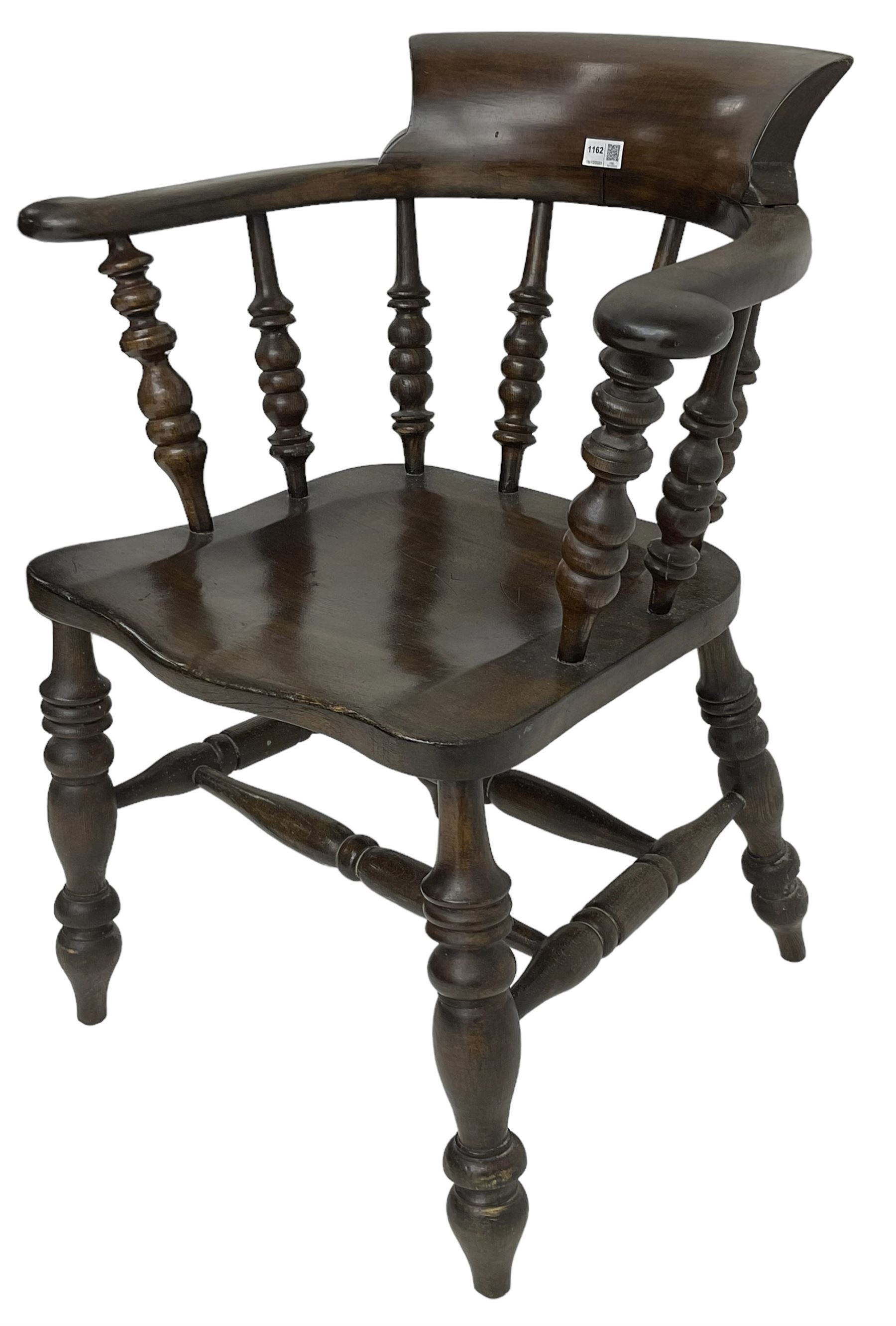 Early 20th century stained beech captains smokers bow chair, spindle tub shaped back over saddle seat, raised on turned supports united by double H-stretcher