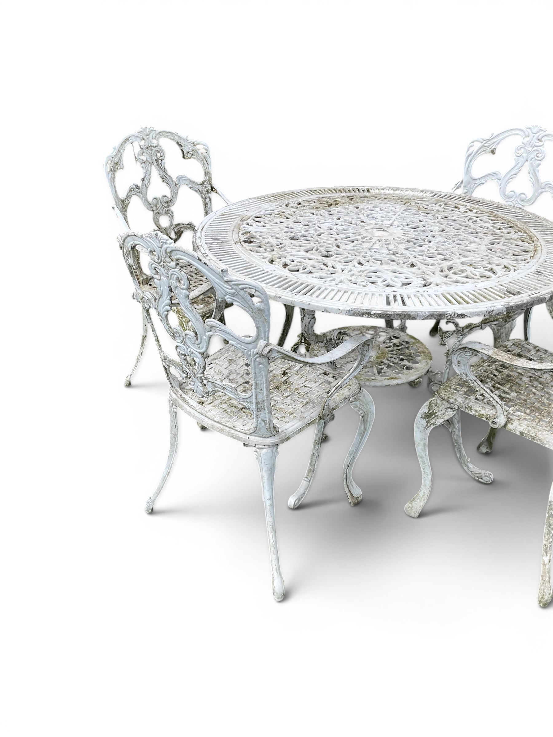 Victorian style cast aluminium white painted garden table and four armchairs chairs with S-scroll acanthus leaf pierced backs over lattice seats
