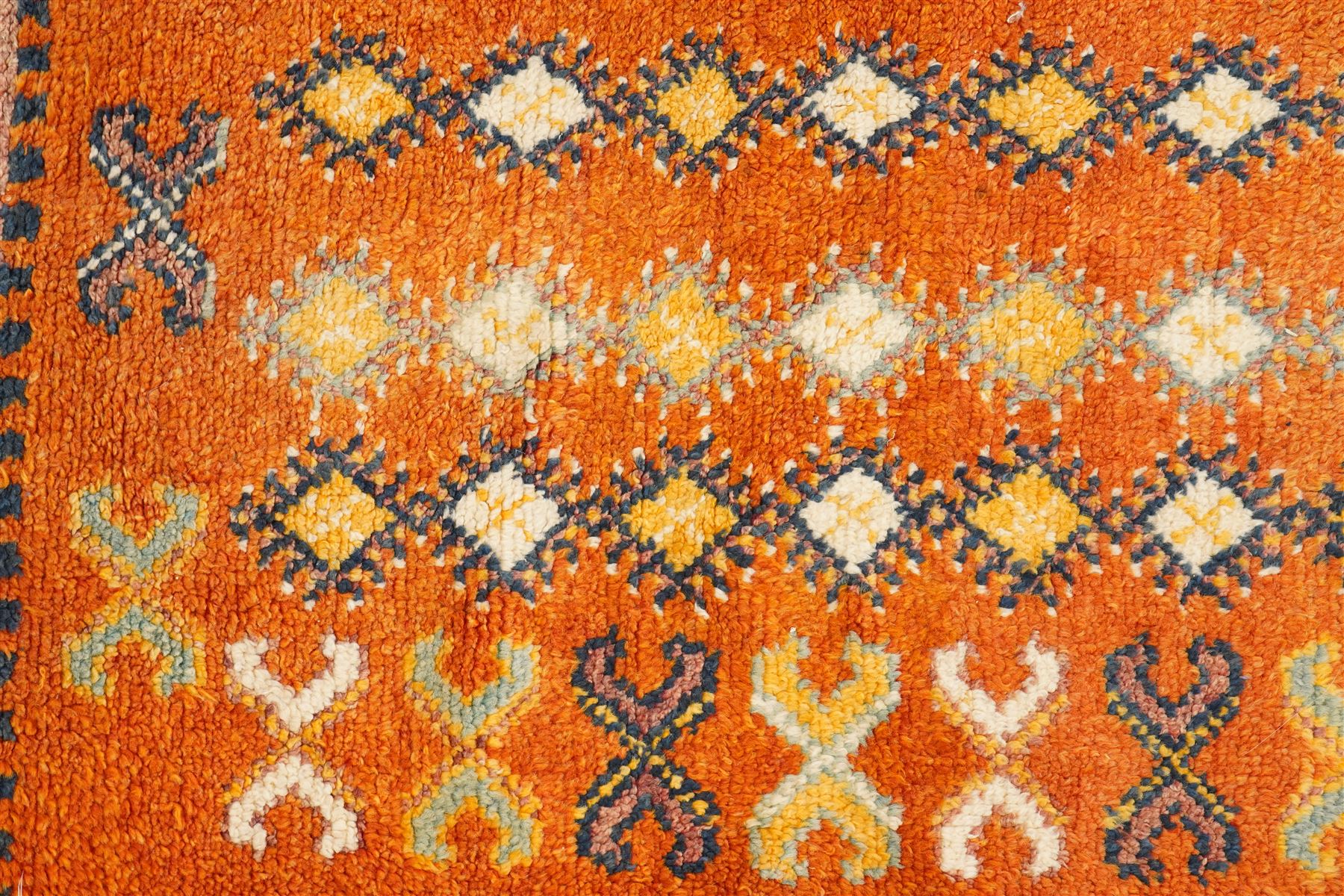 North Persian tribal rug, an orange field and six rows of lozenges, with a border of ram's horn motifs
