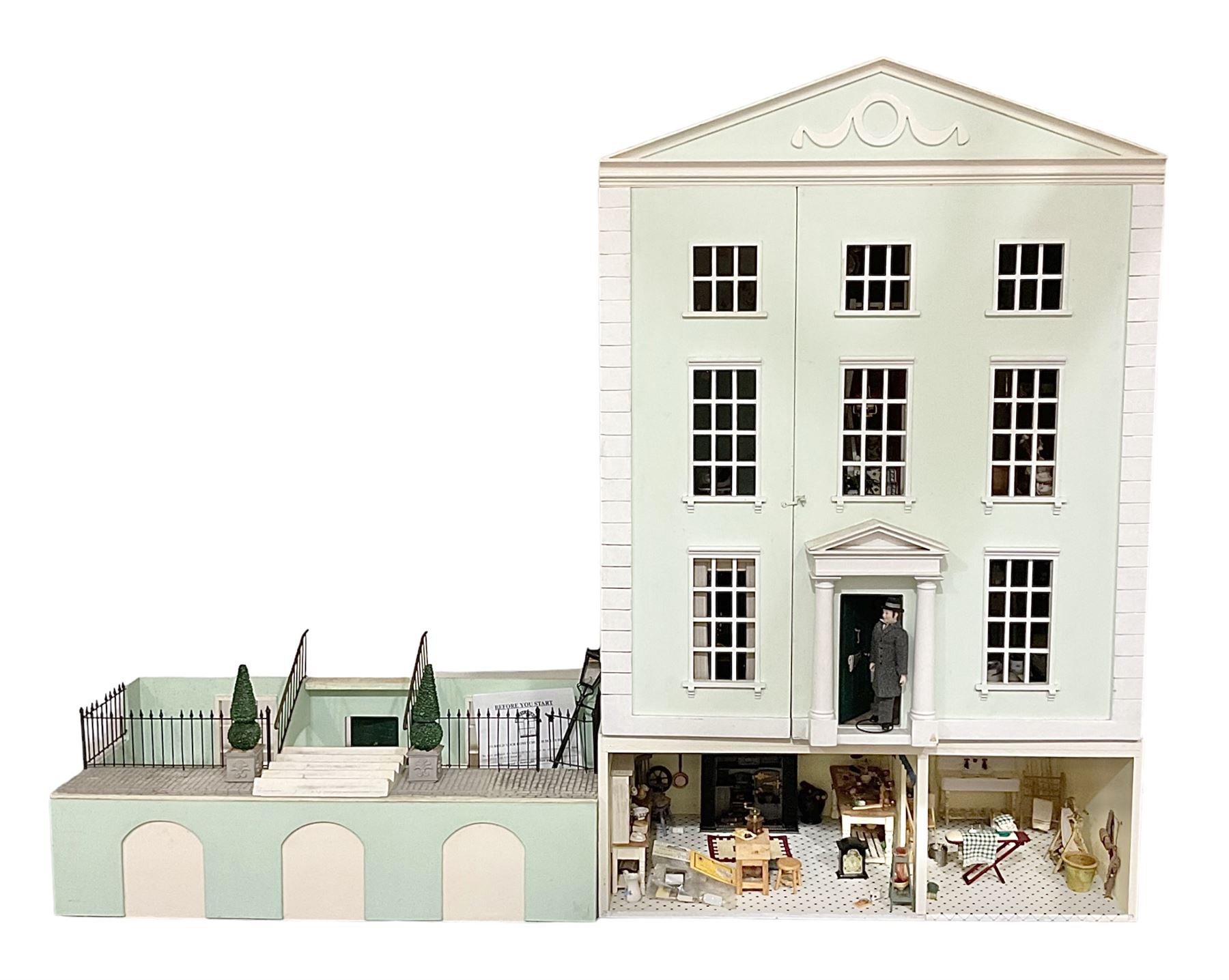 Honeychurch kit-built large wooden dolls house as a 19th century style double fronted four storey town house; with stucco finish under a pitched roof with Palladian style pediment and simulated tiles; protruding front courtyard with railings, street light and steps giving access to two fully furnished basement rooms; central door with Ionic columns and entablature; double hinged front facade opening to reveal a fully furnished interior with hall, stairs and landings and two rooms on each floor; wired for electric wiring W67cm H102cm D58cm