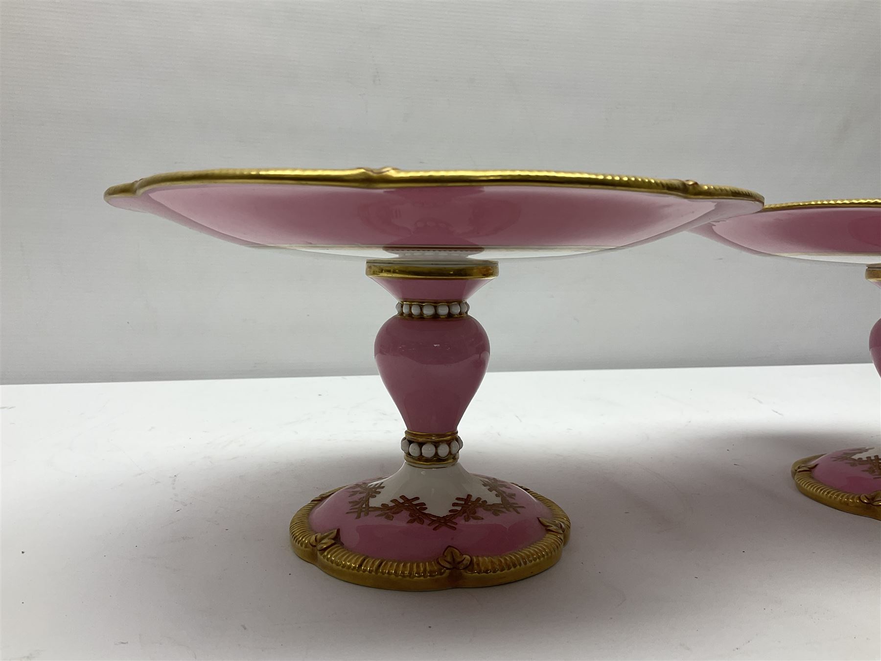 Victorian dessert service, comprising four comports and nine plates, each decorated with floral sprigs to the centre with a pink and gilt border, largest comport H13cm, plate D22.5cm