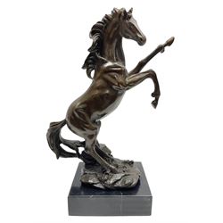 Bronze figure, modelled as a rearing horse, upon a rectangular black marble base, H27cm 