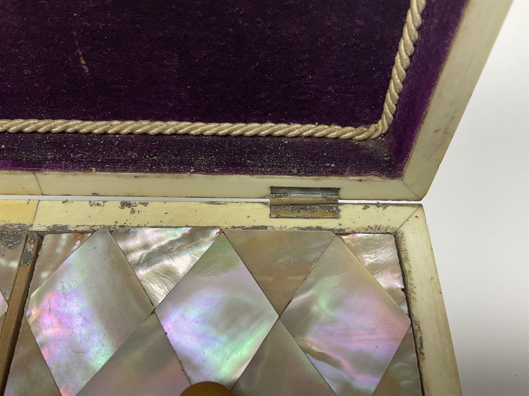 Victorian mother of pearl tea caddy, of rectangular bow-fronted form, the body with floral, bird and geometric engraved mother of pearl panels, white metal shield plaque to the cover inscribed with the initials G.J.A and similar escutcheon, the two division interior with ivory edging and two panelled mother of pearl lids, on four vegetable ivory bun feet L20cm, together with a similar style mother of pearl card case (2) This item has been registered for sale under Section 10 of the APHA Ivory Act