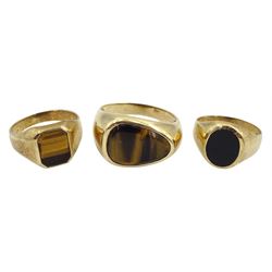 Two gold tigers eye rings and a black onyx signet ring, all stamped 9ct