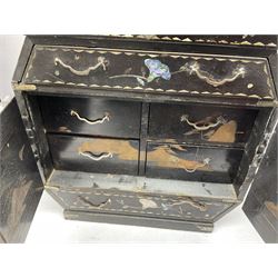  Late 19th / early 20th century Japanese lacquered table top cabinet, heavily decorated with mother of pearl inlay depicting blossoming branches, flowers and birds, the two hinged doors between longer drawers opening to reveal interior fitted with four short drawers, with lift up hinged canted lid, H28cm D9.5cm W23cm, together with mother of pearl inlaid miniature folding screen, dish decorated with walking figures with crimped edge, boxes decorated with flowers, birds and gilt etc