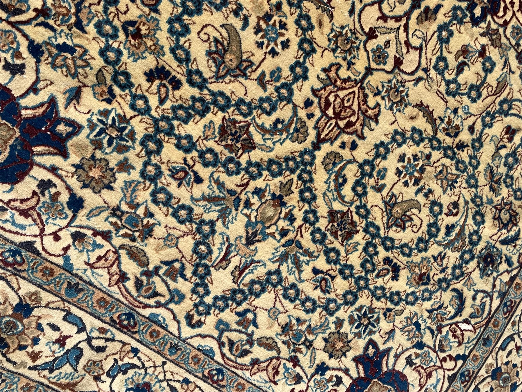 Persian Kashan ivory ground rug, wool with silk inlay, central floral rosette medallion surrounded by trailing flower heads and interlacing leafy branches, the repeating scrolling border decorated with palmettes, within guard stripes