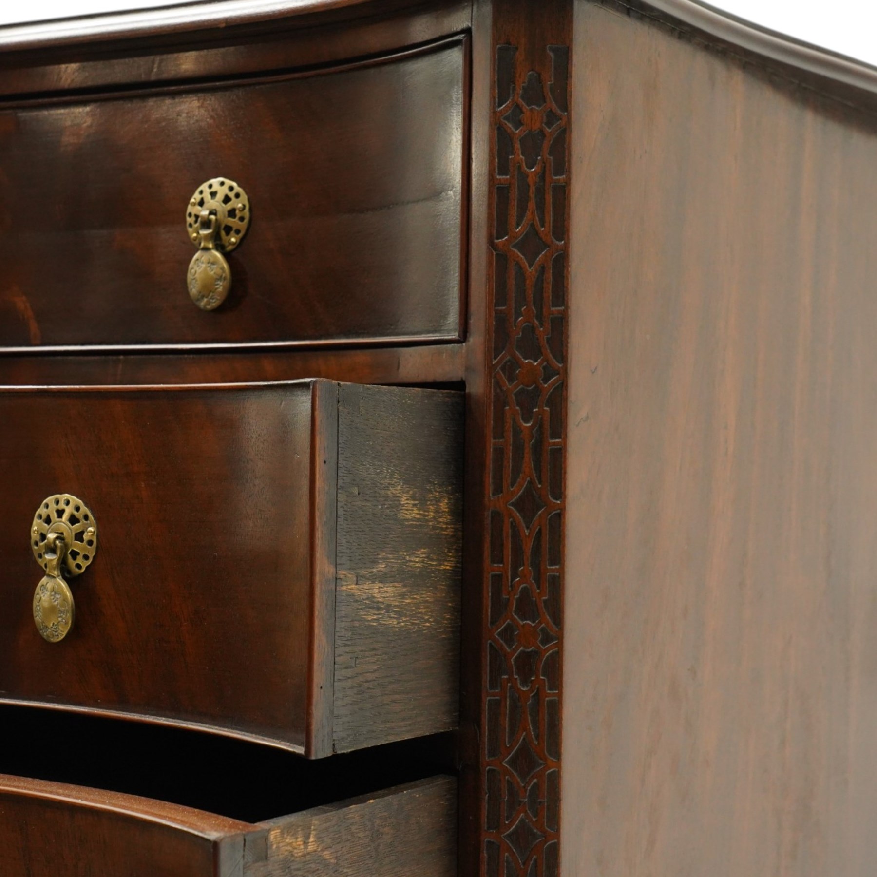 Quality Georgian design mahogany serpentine secretaire chest, the shaped top with moulded edge, fitted with cock-beaded secretaire drawer with button-release fall-front enclosing fitted interior, over three graduating drawers with brass drop handles on pierced circular plates, the canted uprights carved with blind-fret strapwork, lower moulded edge on shaped bracket feet