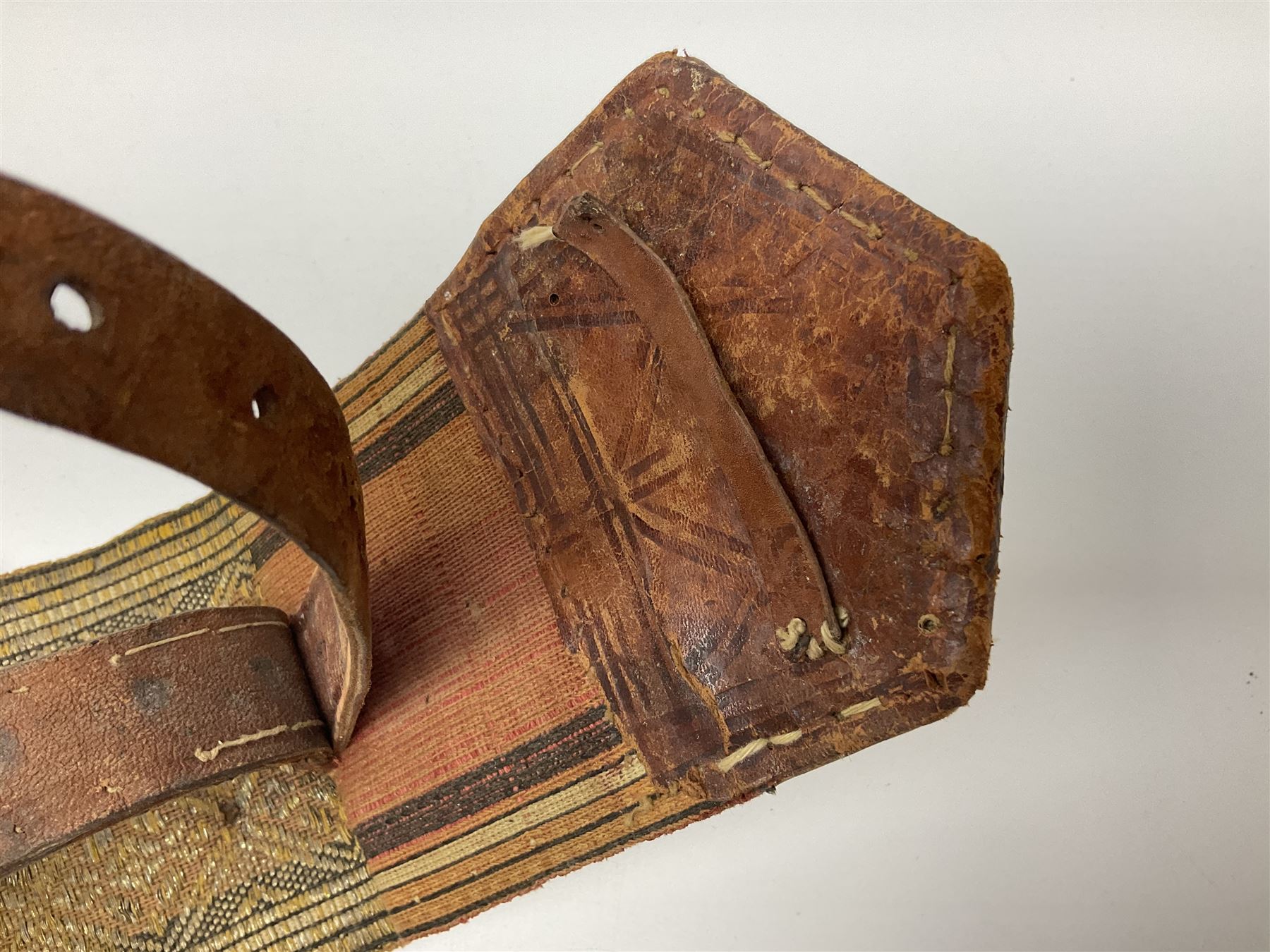 Late 19th century Yemeni Tuza jambiya as worn by religious elite, the 20.5cm curving blade with raised medial ridge, the horn hilt with pique style studwork, in a leather wrapped wooden scabbard with pierced metal mount and leather belt applied with embroidered 'gold' and 'silver' thread work panel; dagger L36cm overall, belt L84cm