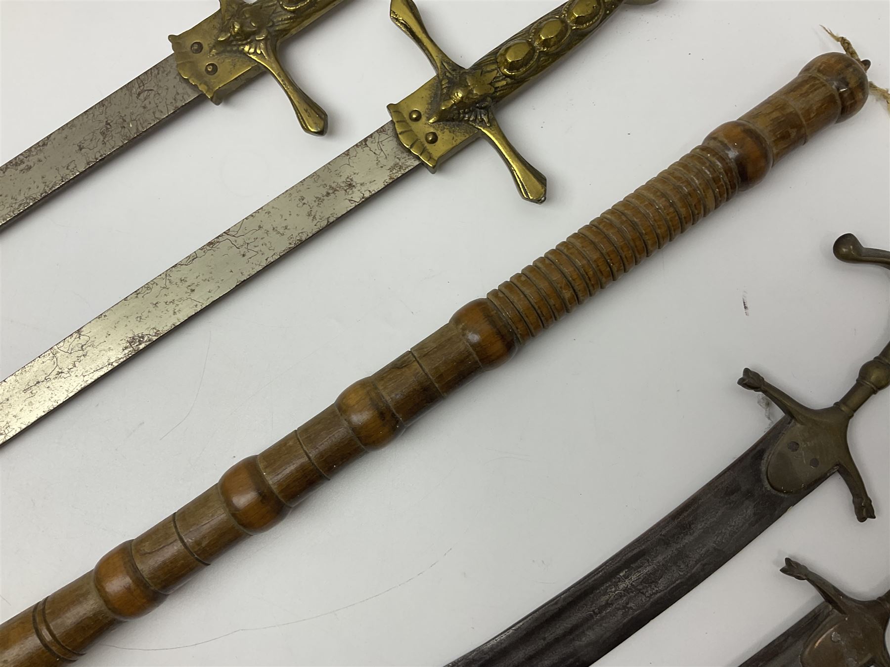 Near pair of short swords each with slightly curving 41cm fullered steel blade and all brass H-shaped hilt L52cm overall; plaited black leather whip; and reproduction pair of brass hilted swords, brass halberd blade and mace (7)