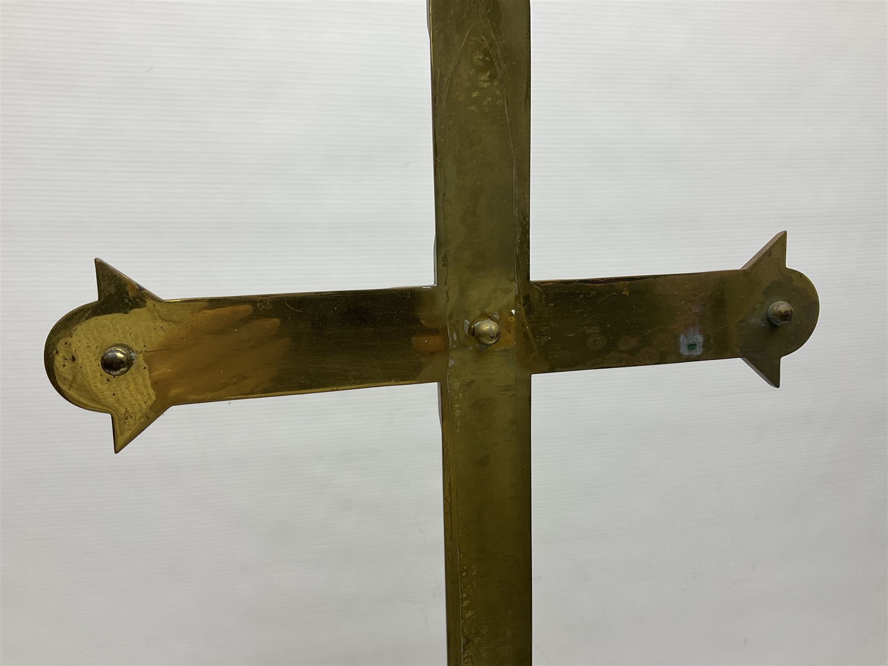 Brass alter cross, decorated with glass cabochons, upon a acicular stepped base and three claw feet, H73cm 