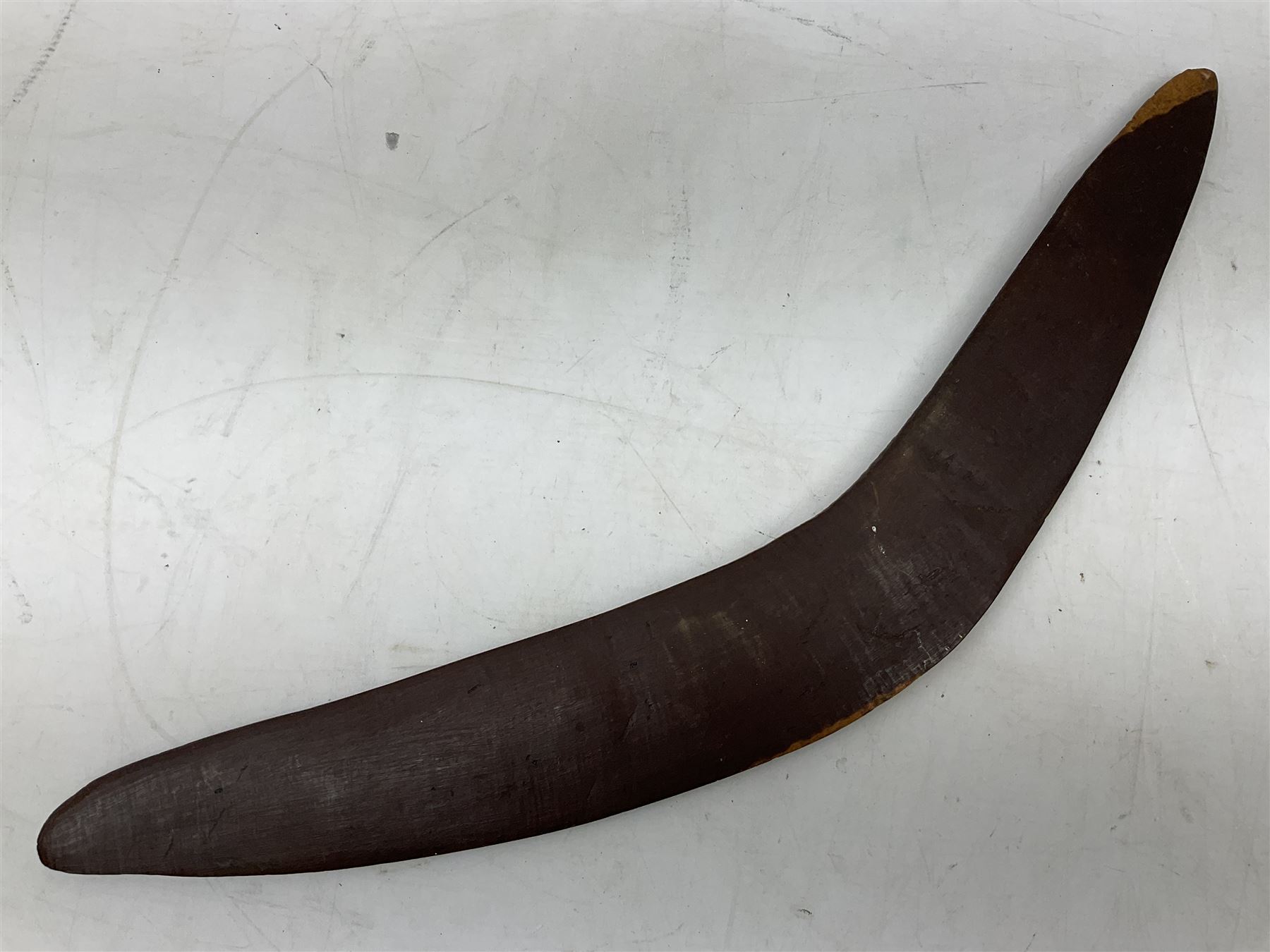 Australian aboriginal woomera spear thrower incised/carved with a wavy line and dots L69cm; and two boomerangs, one with carved geometric decoration (3)