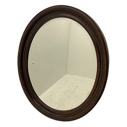 Early 20th century oval wall mirror, scumbled wood finish, bevelled plate in moulded frame