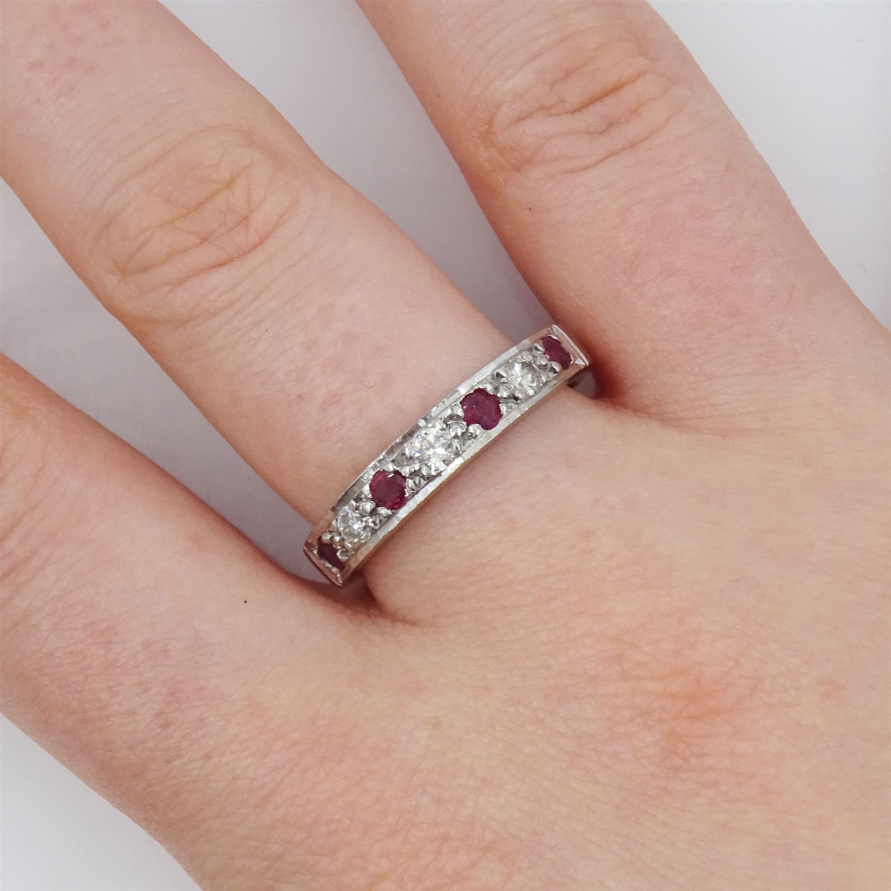 18ct white gold ruby and round brilliant cut diamond half eternity ring, London 1978