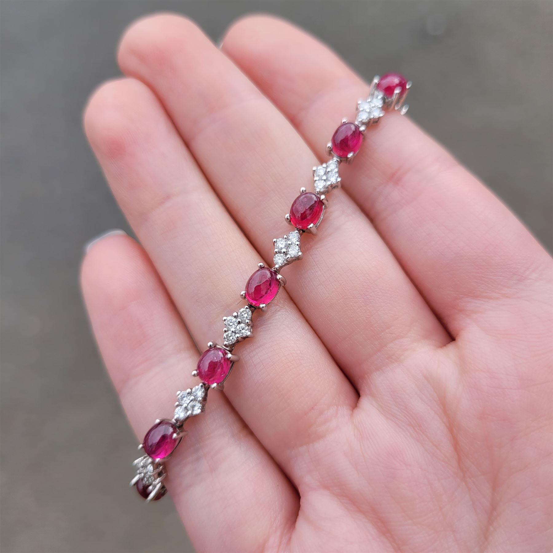 18ct white gold ruby and diamond bracelet, fifteen oval cabochon cut rubies, each spaced by four round brilliant cut diamonds, Sheffield 2009, total ruby weight 10.10 carat, total diamond weight approx 0.60 carat