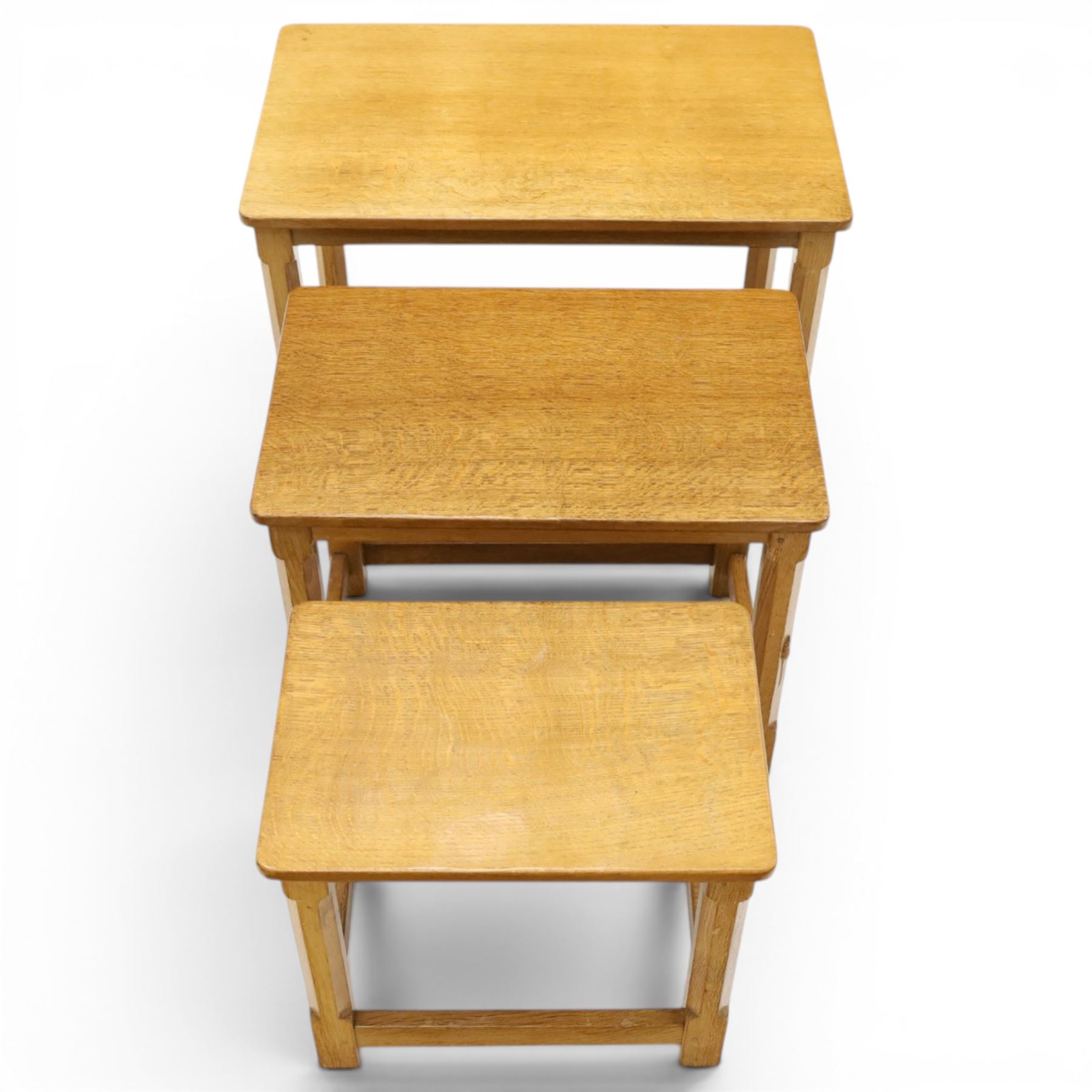 Mouseman - set of three adzed light oak nesting tables, each with rectangular top raised on octagonal legs joined by stretchers, with signature carved mouse, by the workshop of Robert Thompson, Kilburn