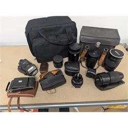 Kodak Dakon II folding camera and a collection of camera lenses and accessories, including Reflex-Nikkor  1:8 f=500mm, NikoN AF Nikkor 70-300mm 1:4-5.6G, Micro TM monocular lens and Teleshot adapter, two cases, Weston exposure meter, two cases etc