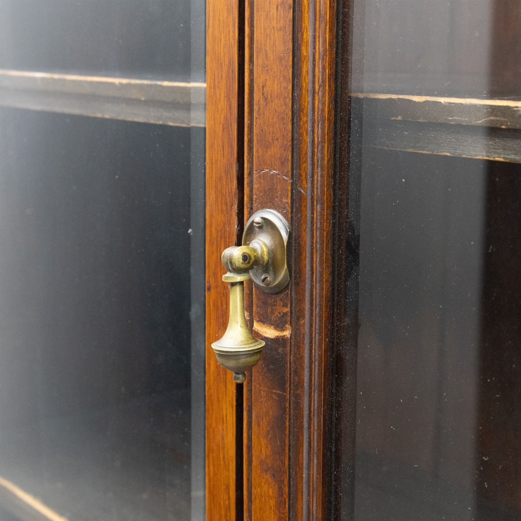 Late 19th century walnut library bookcase, fitted with four display doors with astragal bevelled panes, raised upon a four cupboard base with fielded panel doors