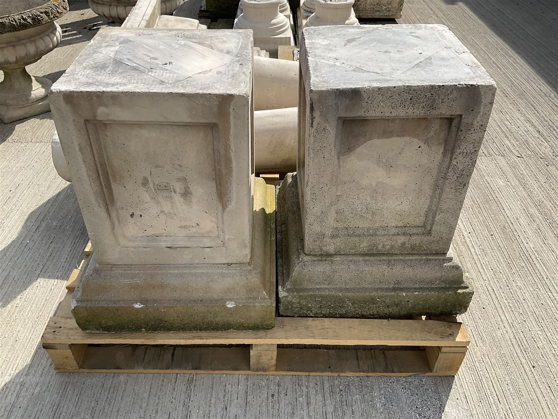 Set of four cast stone architectural columns, tapering form, on square plinth bases