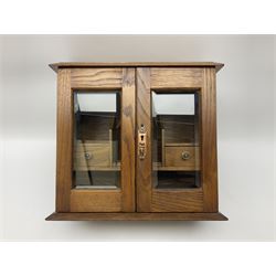 Table top oak smoker's cabinet, the glazed cupboard enclosing two short drawers and shelves, with a hinged lid, H30cm