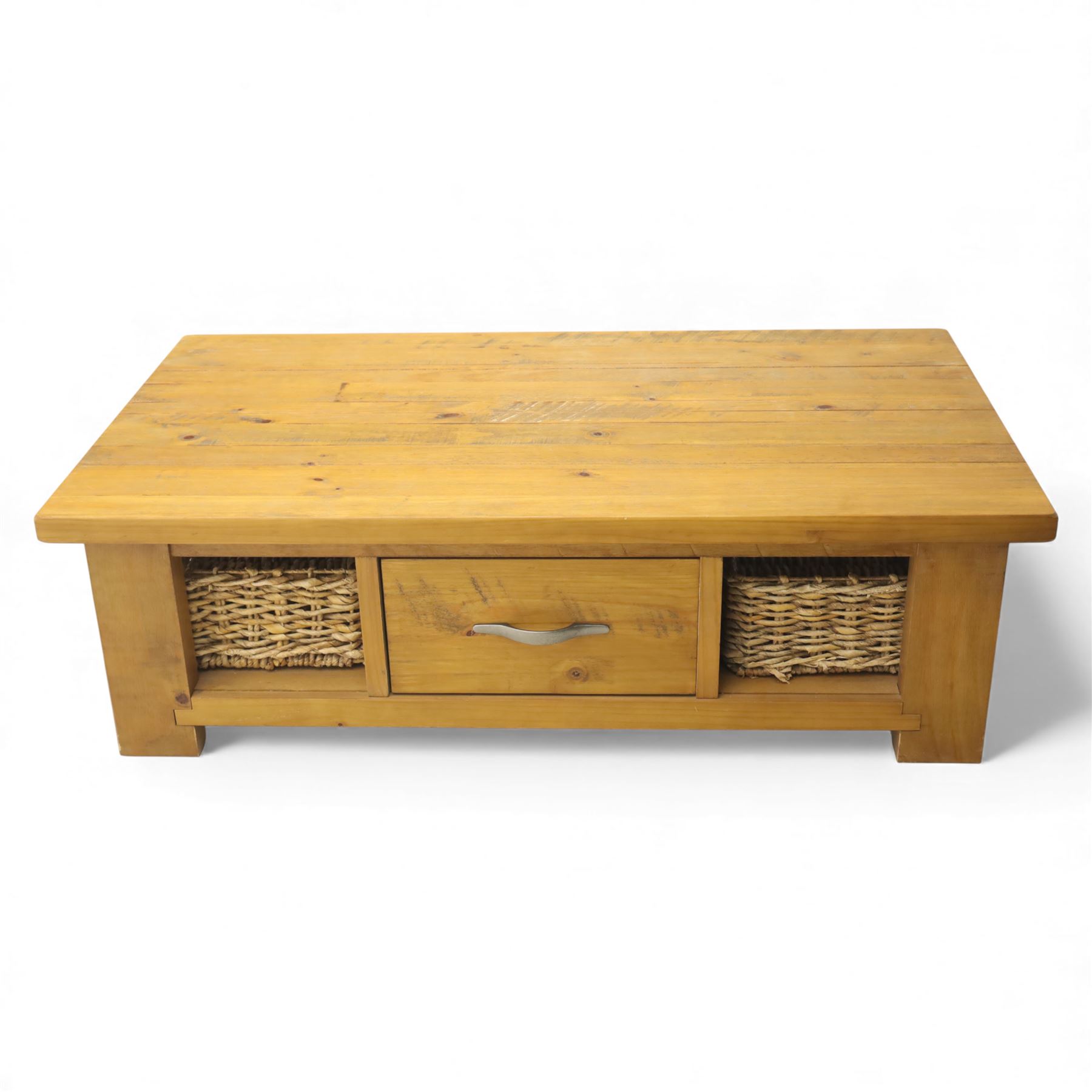 Contemporary pine coffee table, rectangular planked top with moulded edge, fitted with a central drawer to either side with brushed metal handle, flanked by two open compartments housing wicker basket drawers, plain sides, raised on square block feet