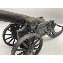 Victorian cast-iron and steel signal cannon, approximately half-inch bore, with 23cm ringed barrel and cylindrical trunnions, on a cast iron carriage with two twelve-spoked wheels and guilloche pierced swept back support, L43cm overall