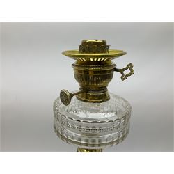 Victorian brass oil lamp, the square stepped base leading to a Corinthian column supporting a part slice cut clear glass reservoir, burner, clear glass chimney and foliate etched glass shade with amber rim, overall H80cm