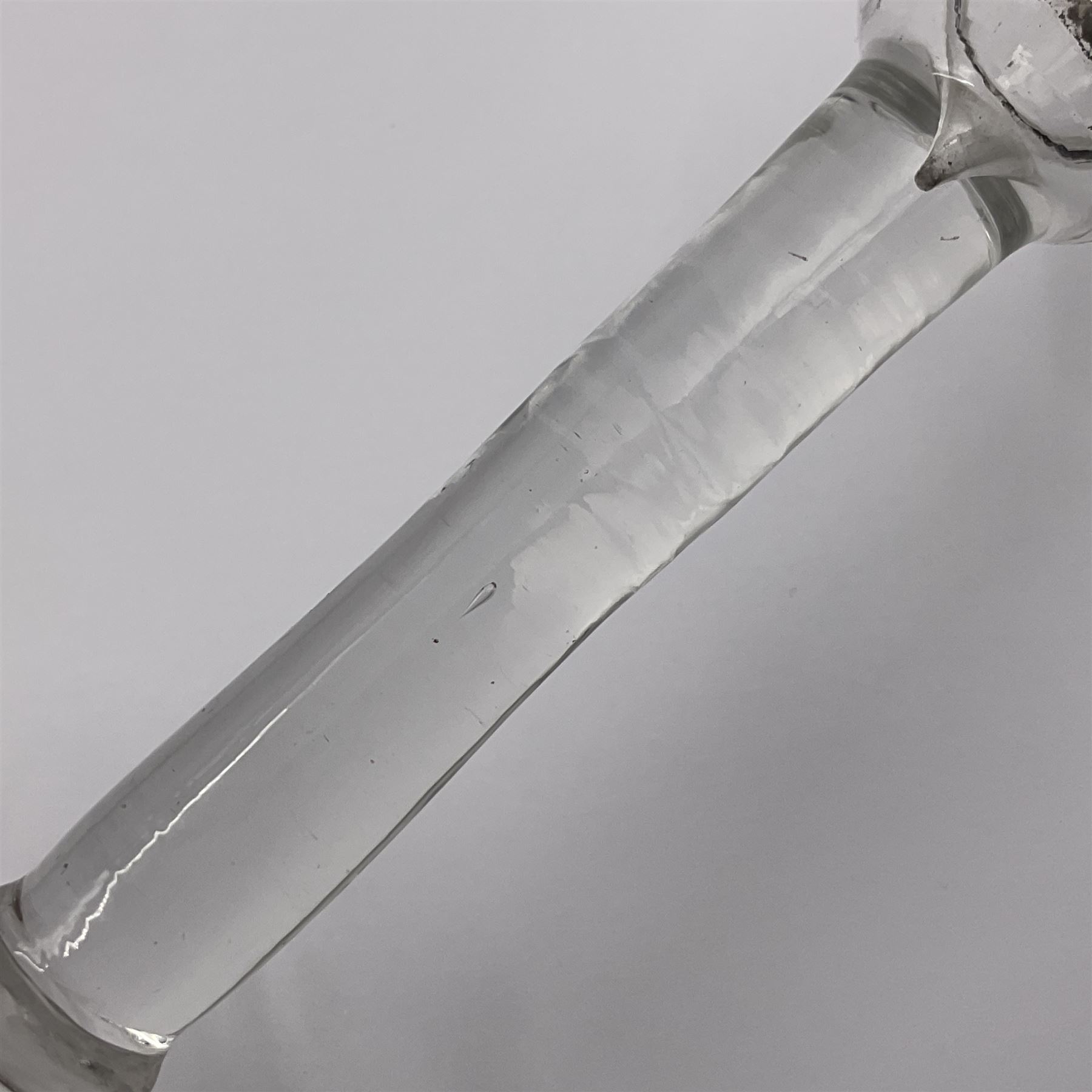 Three 18th century wine glasses comprising a plain stemmed glass with bell shaped bowl and conical folded foot H16cm, another plain stemmed glass with ogee bowl and folded foot and a Continental glass with gilt faceted bowl, decorated with male figure within a landscape, on a clear Silesian seven sided cut stem (3)