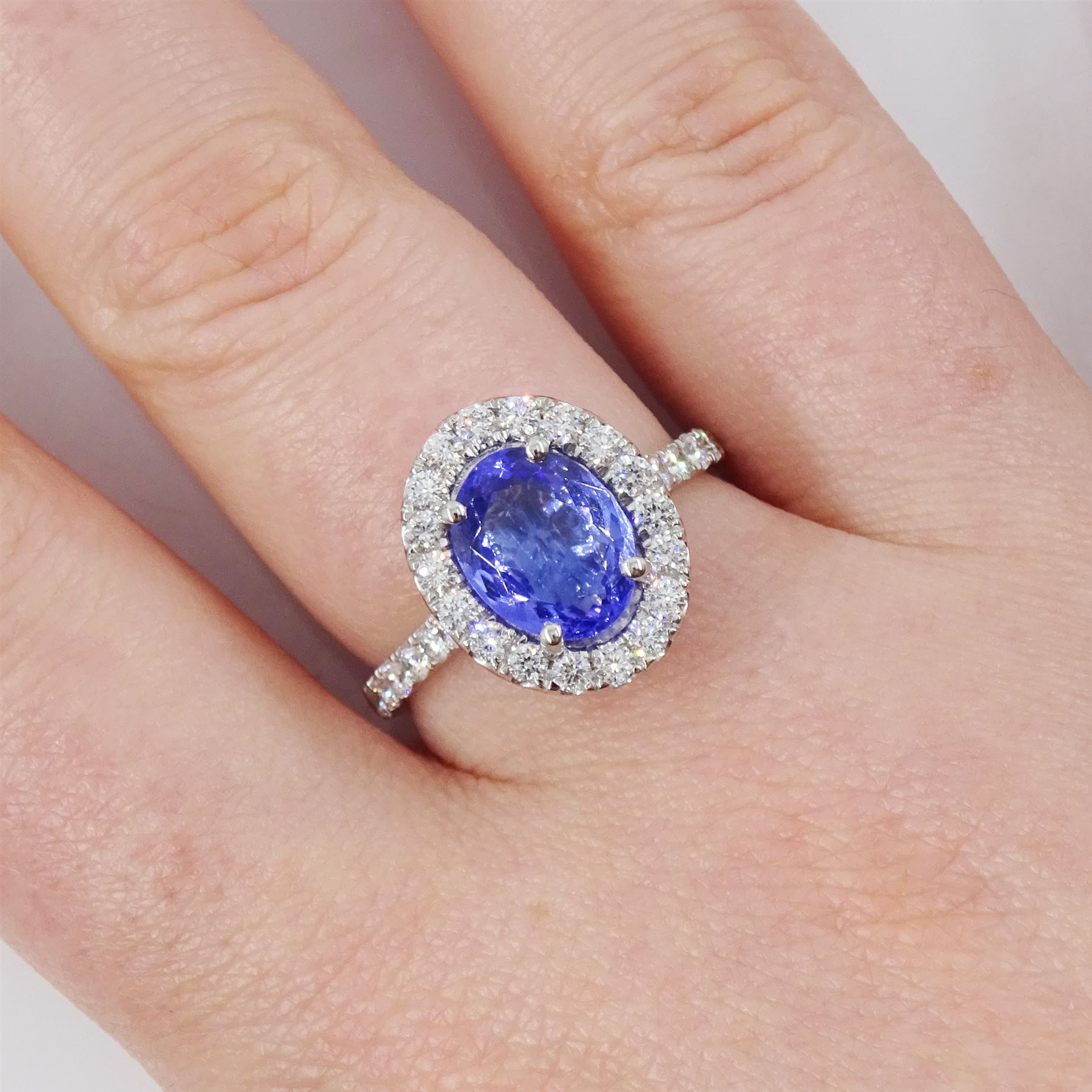 Platinum tanzanite and diamond cluster ring, single oval tanzanite of 2.36 carat, with round brilliant cut diamond surround and diamond set shoulders, hallmarked, total diamond weight 0.76 carat, with World Gemological Institute report