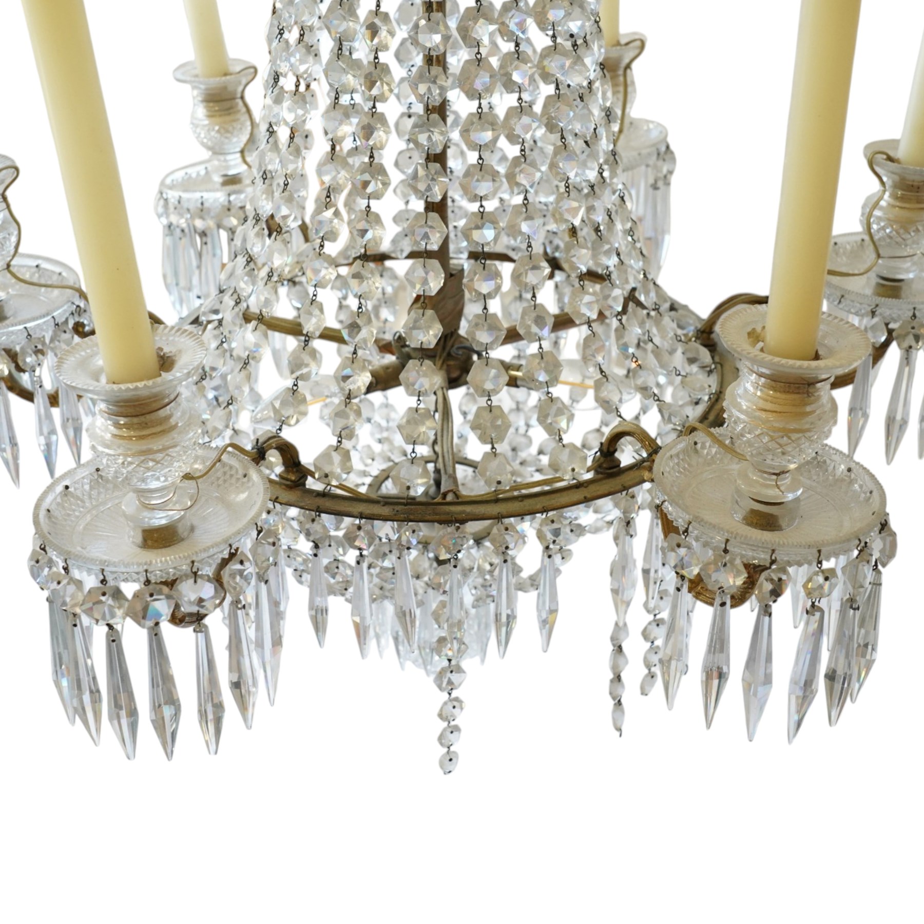 Regency Country House cut-glass and ormolu six light chandelier, the outer shaft with ormolu foliate moulding hung with octagonal and drop pendants, the impressive central shaft with cascading drops of cut-glass, the scroll branches with hob-nail cut candle holders and wax pans, with central similarly cut terminal
Provenance: property of a nobleman
