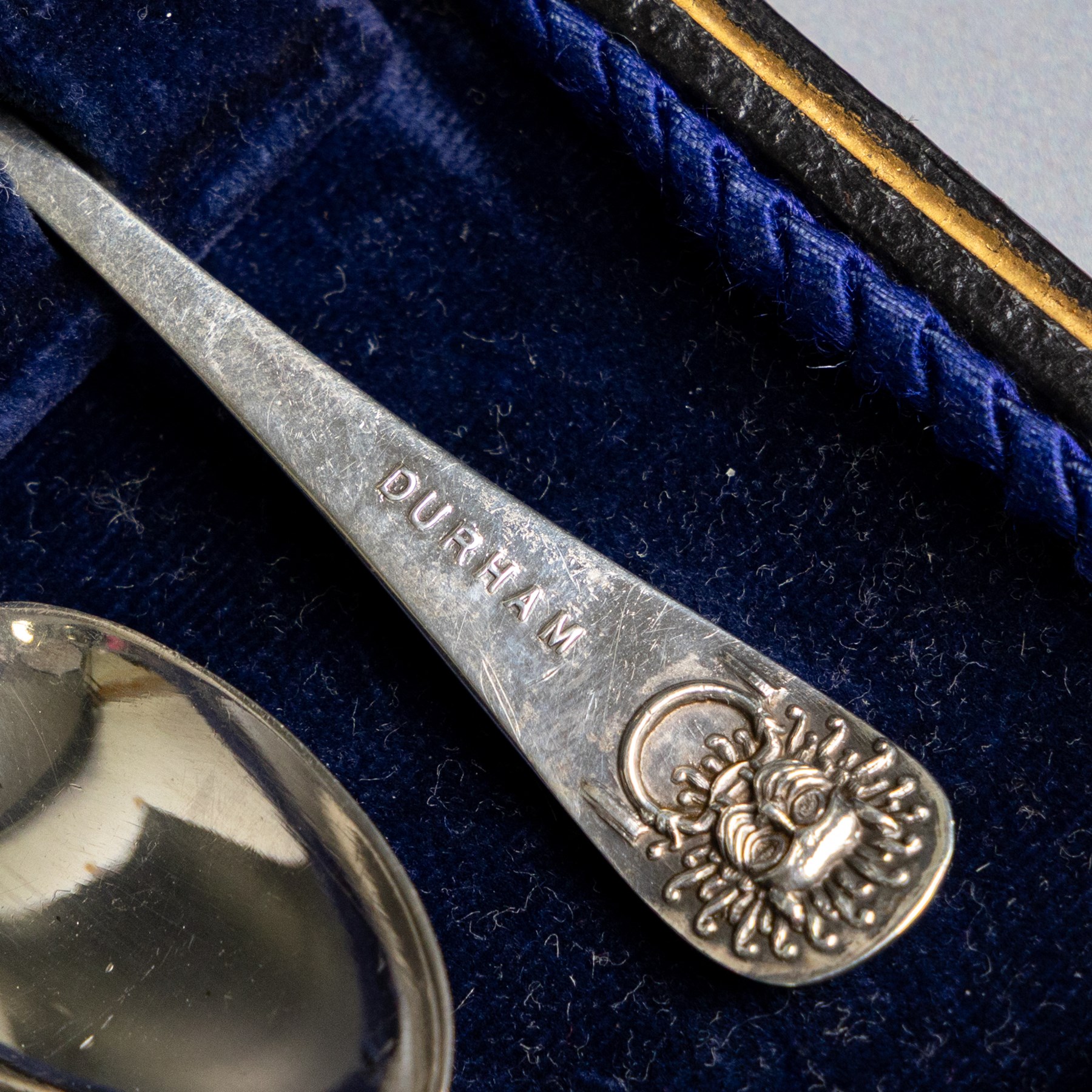 Set of six 1920s silver teaspoons and pair of sugar tongs, each decorated in relief with the Durham Cathedral sanctuary knocker and with rattail bowls, hallmarked Cooper Brothers & Sons Ltd, Sheffield 1923, contained within a fitted case