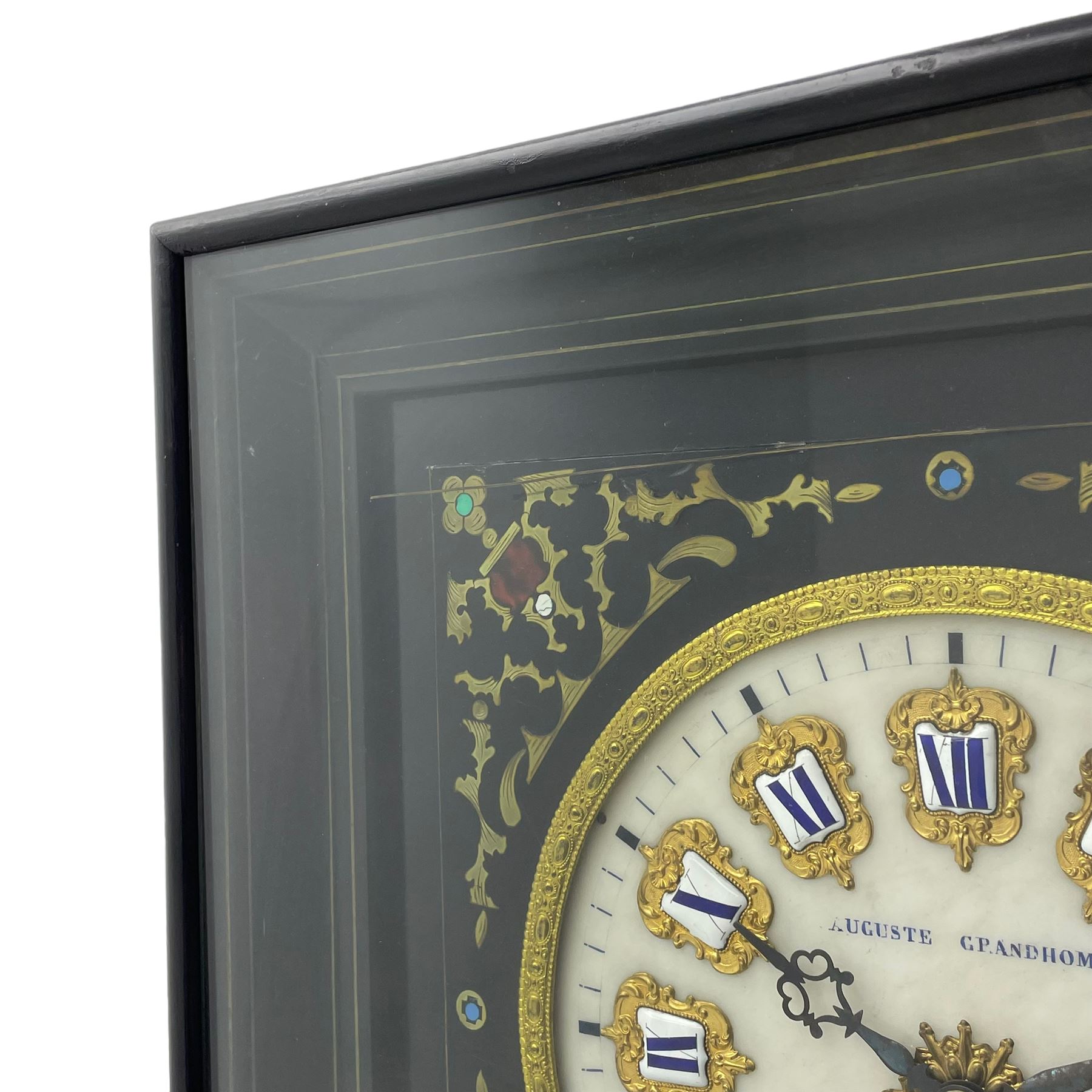 Auguste GP. Andhomme - French vineyard clock,  late 19th century 8-day twin train spring driven wall clock with enamelled and inlaid brass decoration within an ebonised and glazed case, circular enamel dial with cartouche Roman numerals, minute markers, pieced steel hands and a chased brass slip, striking movement, sounding the hours and half hours on a coiled gong. With pendulum and key.  
