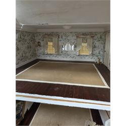 Two modern three storey dolls houses, each painted green with decorated interiors, both upon a single white wooden base, together with a large collection of dolls house furniture, accessories and figures 