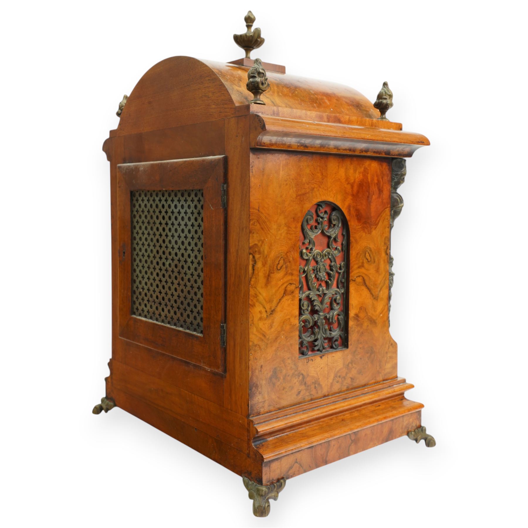 German-early 20th century mantle clock c1910, in a walnut case with a break arch top and decorative cast brass finials, brass silk backed sound frets to the sides and a glazed break-arch door flanked by a pair of cast brass caryatid, on a dee ogee moulded plinth and raised on splayed paw feet, brass dial with cast spandrels and a matted dial centre, silvered chapter ring with Roman numerals, gothic steel hands and a conforming pendulum regulation dial to the arch, two train going barrel movement with rack striking, sounding the quarters on two gongs and the hour on one, With Pendulum and key.
