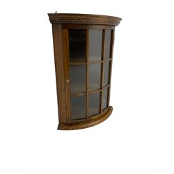 Oak bow-front corner unit, astragal glazed door enclosing two shelves