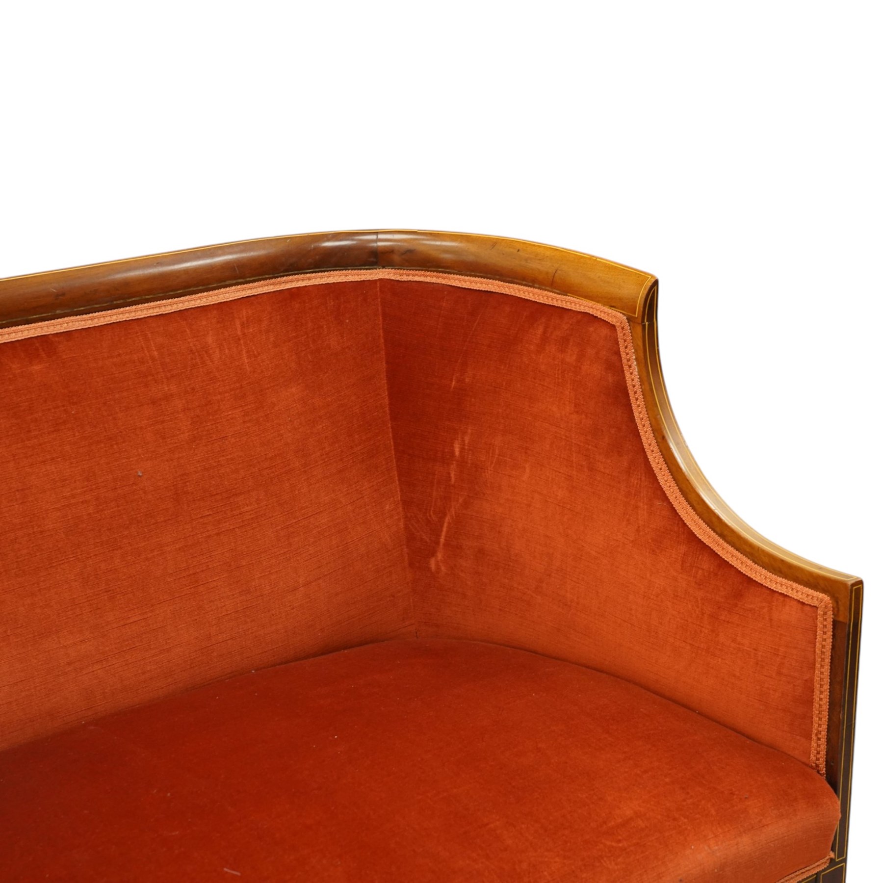 Edwardian inlaid mahogany tub two seater settee, traditional shape with satinwood stringing, upholstered in crimson fabric with sprung seat, on square tapering supports with castors