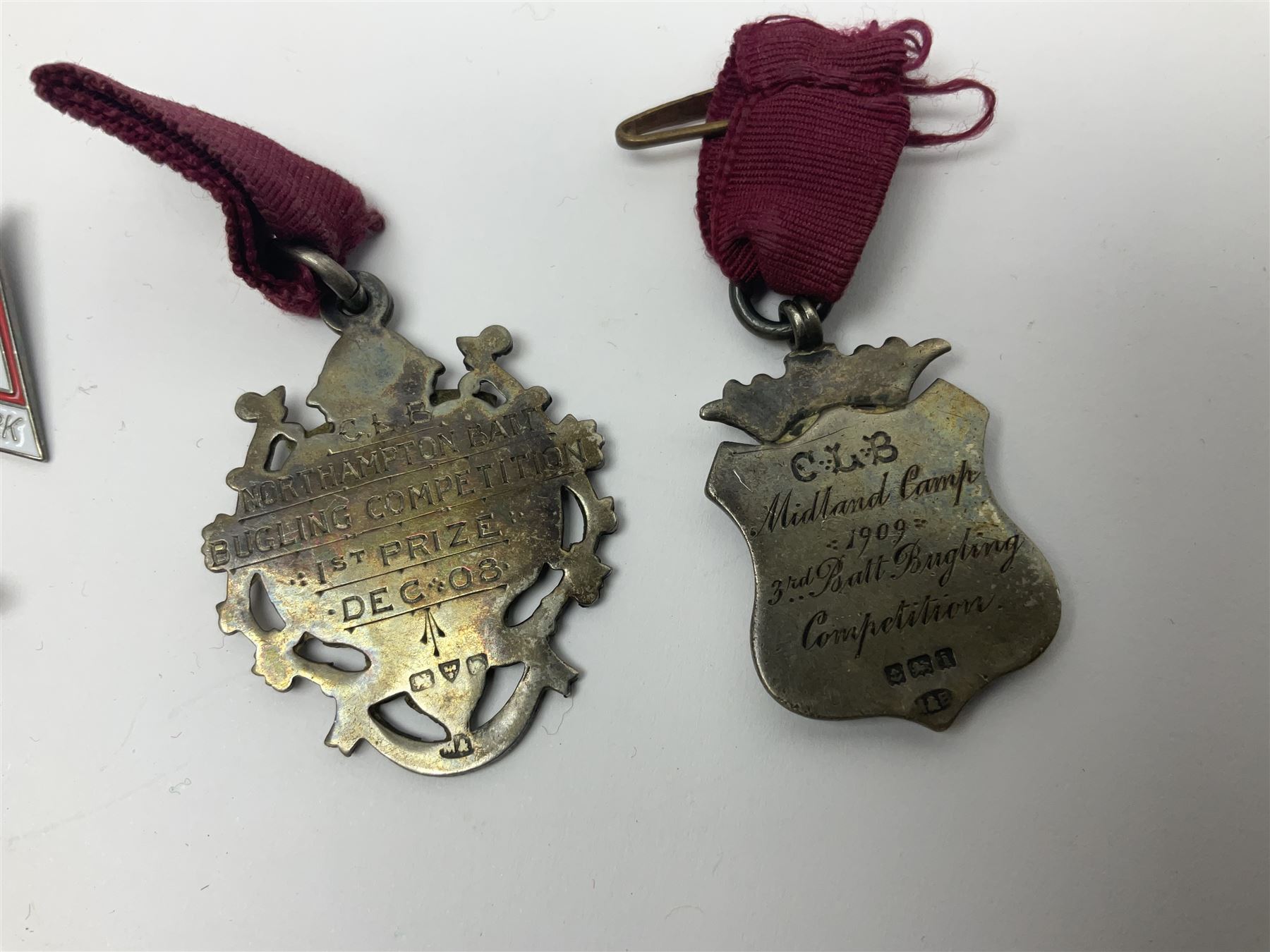 Two Edwardian hallmarked silver presentation fobs for military bugling competitions; and quantity of cap/glengarry and other badges, sweetheart brooches etc