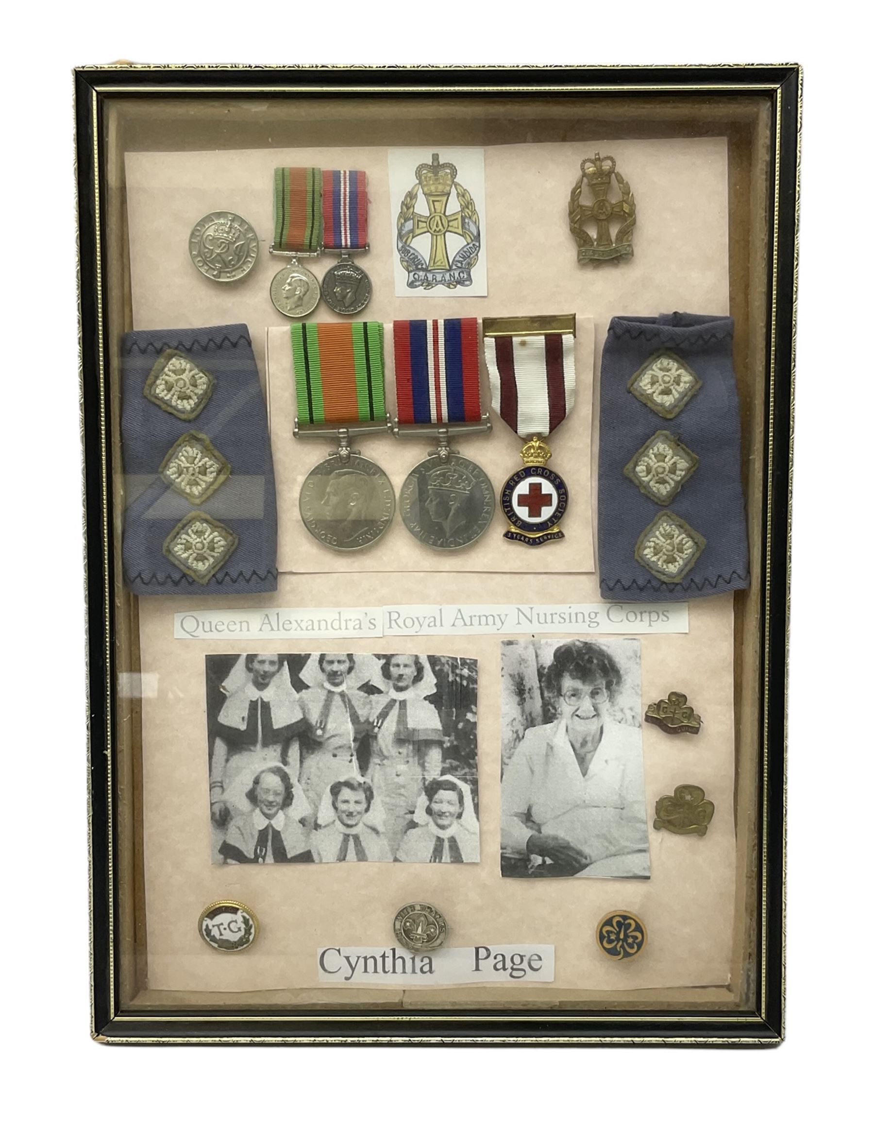 Framed display of medals and badges relating to Captain Cynthia Page of Queen Alexandra's Royal Army Nursing Corps including WW2 War Medal and Defence Medal with miniatures; Red Cross Society 3-Year Service Medal; Q.A.R.A.N.C. cap badge; Girl Guide and silver Scout badges; rank epaulettes; and related photographs 33 x 23cm
