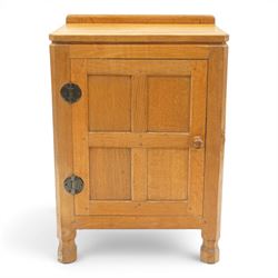 Mouseman - adzed and panelled oak bedside cupboard of small proportions, raised back over ...