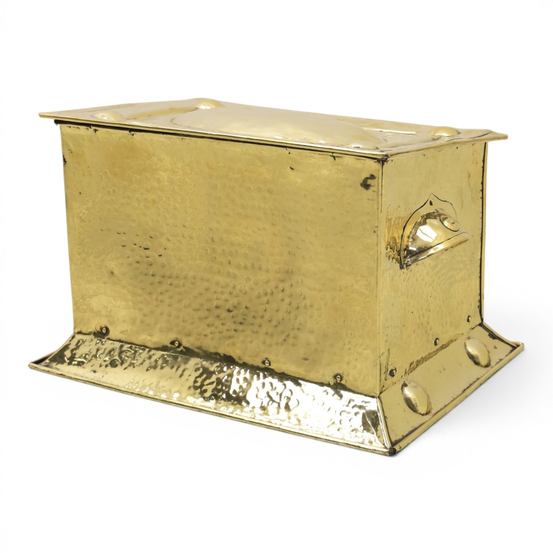 Art Nouveau brass coal box, the hinged rectangular cover embossed with a foliate design, hammered panelled sides with shaped carrying handles, on projecting plinth base with applied roundels