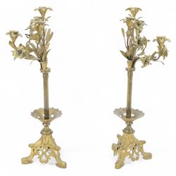 Pair of late 19th century gilt cast candelabra, each with scrolling tripartite base leading to an acanthus detailed circular pan and plain stem, supporting three arms entwined with lily flowers and leaves, the sockets also modelled as lily flowers, H60cm