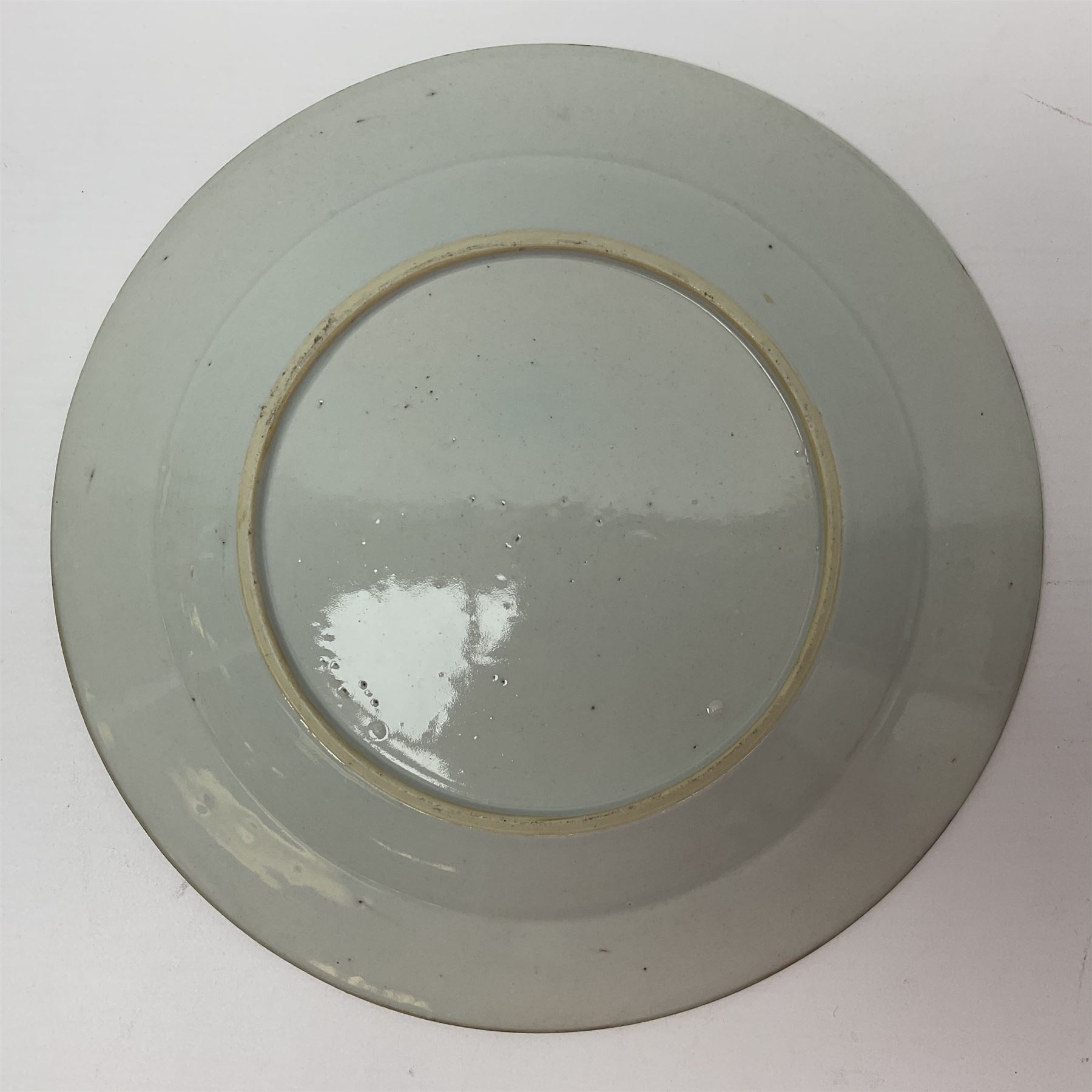 Three 18th century Chinese Famille Rose plates, the first example enamelled with blossoming peonies, rockwork and fence, the other two examples of similar design, decorated with blossoming peonies and sprigs within shaped inner borders, each approximately D23cm