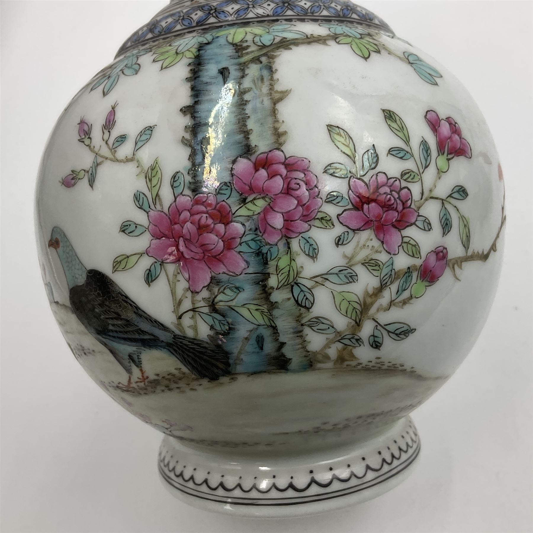 Pair of Chinese Republic porcelain vases, each painted in Famille Rose enamels with pairs of pigeons amidst peony, rock, flowering plants and leafy branches, possibly Qianlong seal beneath, H22cm 