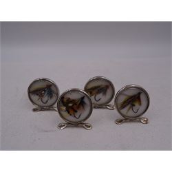 Set of four early 20th century silver mounted place card holders, each of circular form and set with a coloured fly fishing hook behind a glazed panel, upon three pad feet, hallmarked Grey & Co, Chester 1912, H4.5cm, contained within red fitted case, with purple silk and velvet interior