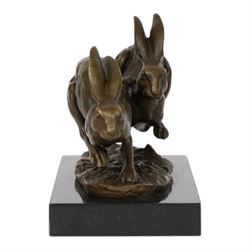 Bronze figure group, modelled two hares in chase, upon naturalistically modelled oval base signed Nick and with foundry mark, raised upon black marble base, H11cm L12.5cm
