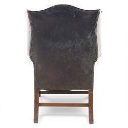 Georgian style leather wing armchair, shaped high back with outscrolled wings above padded arms and deep buttoned seat, close-nailed throughout, raised on square supports united by H-stretcher