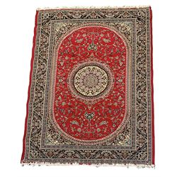Persian red ground rug, circular central ivory medallion, the curved rectangular field decorated with interlacing branch and stylised plant motifs, the border with repeating floral scroll design