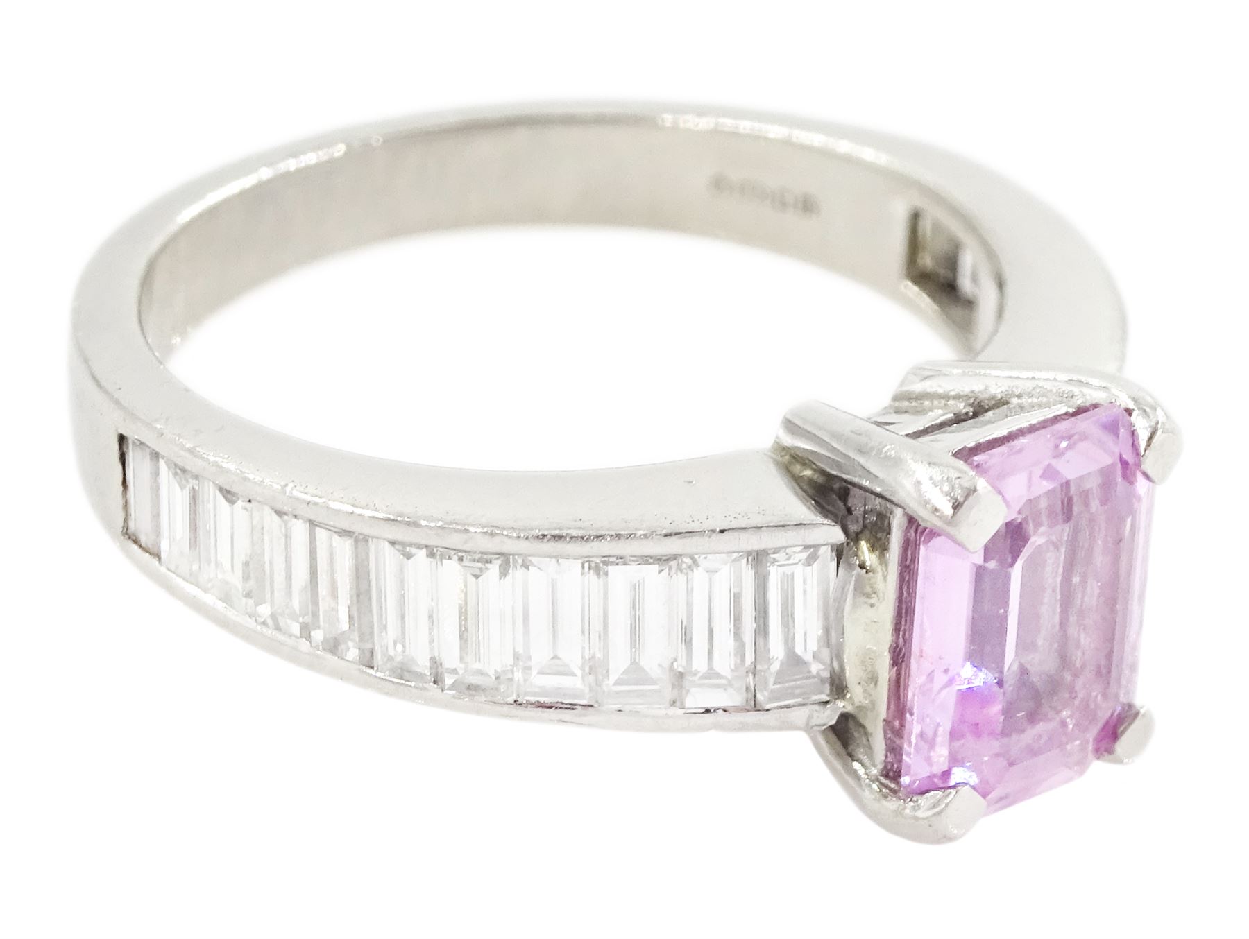 Platinum pink sapphire and diamond ring, single octagonal cut sapphire of approx 1.50 carat, each shoulder set with eleven, channel set baguette cut diamonds, London 2007, total diamond weight approx 1.05 carat