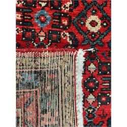 Persian crimson ground runner, the field decorated with Herati motifs,  three-band border, the main band decorated with repeating flowerheads 